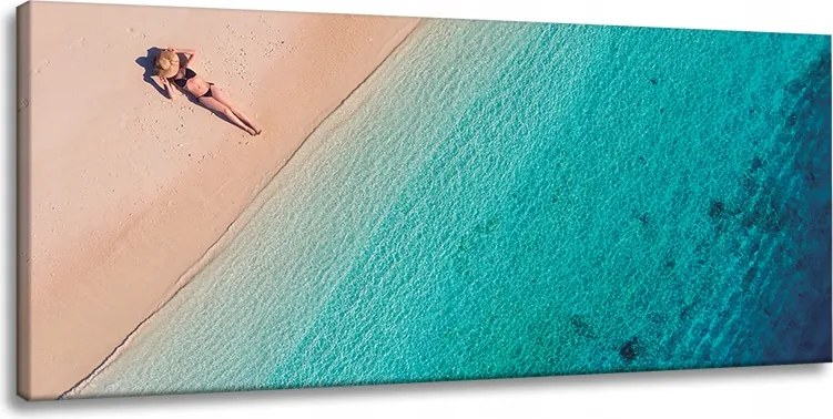 Vászonkép Nő napozik a tengerparton 120x60 cm