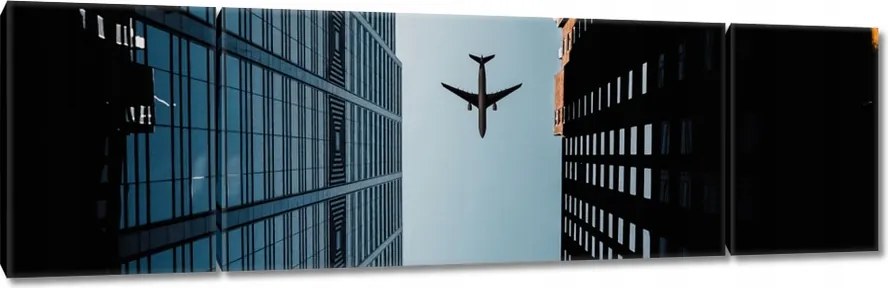 Vászonkép 170x50 Repülőgép az épületek között
