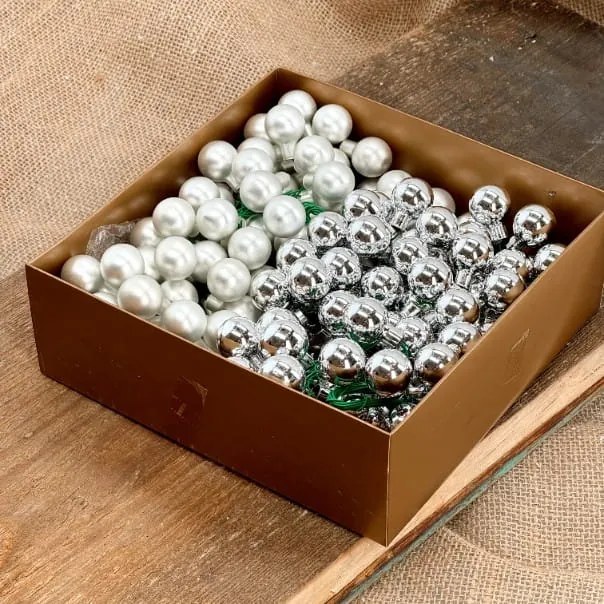 Üveggömbök dróton ezüst 1,5 cm 144 db arany dobozban