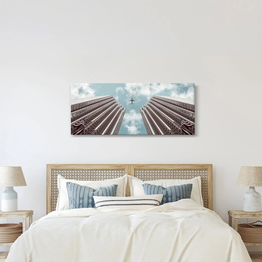Repülőgép az épületek között képe (120x50 cm)