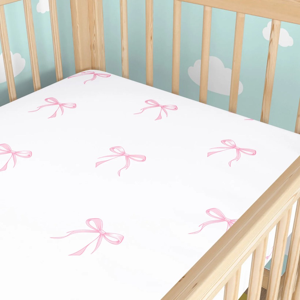 Goldea gyermek gumis pamut lepedő kiságyba - rózsaszín masnik 60 x 120 cm