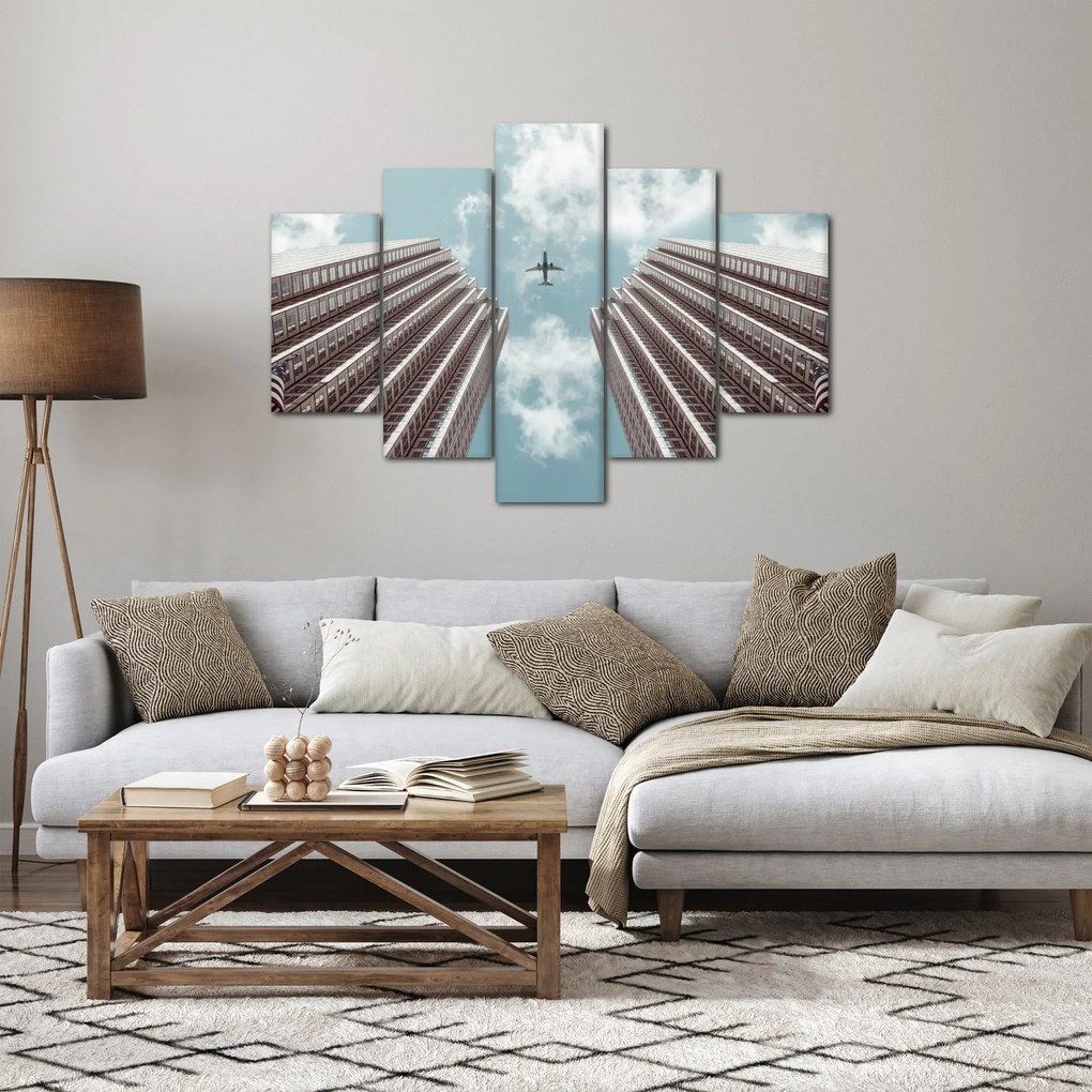 Repülőgép az épületek között képe (150x105 cm)