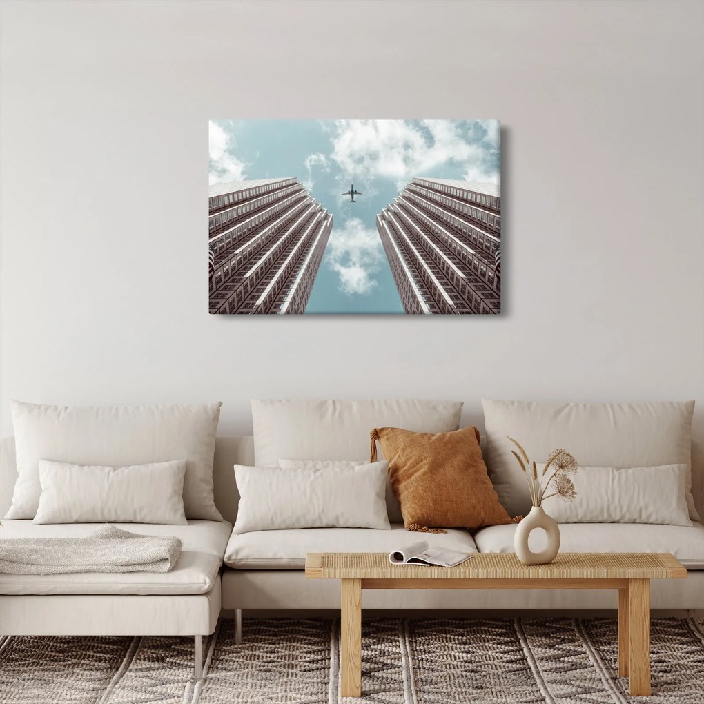 Repülőgép az épületek között képe (90x60 cm)