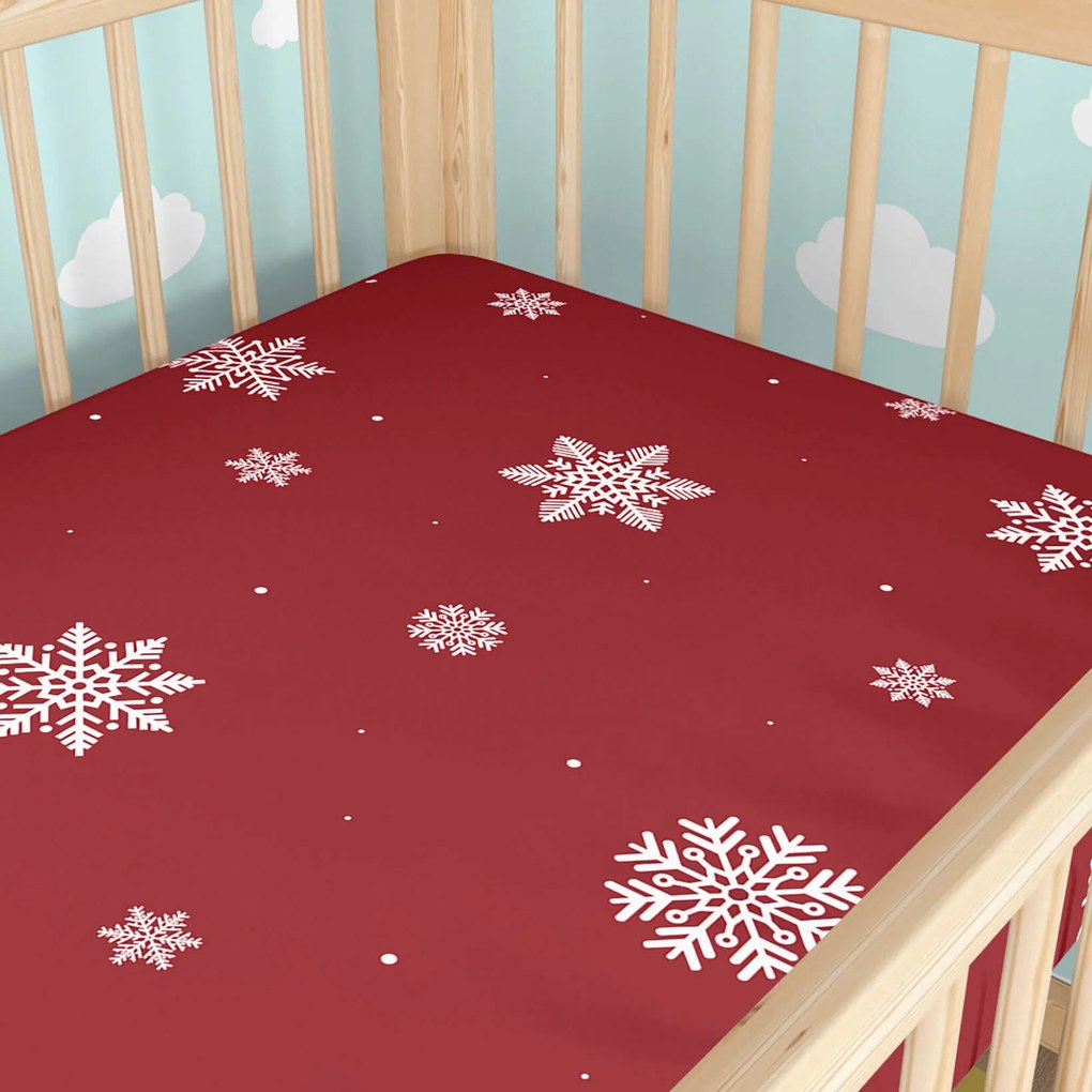 Goldea karácsonyi gyermek körgumis pamut lepedő kiságyba - hópelyhek piros alapon 70 x 140 cm