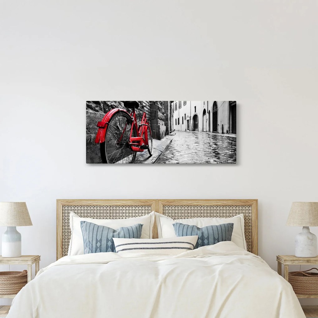 Egy vörös kerék képe egy macskaköves utcán (120x50 cm)