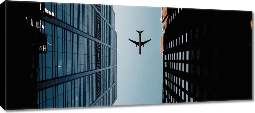 Vászonkép 100x40 Repülőgép az épületek között