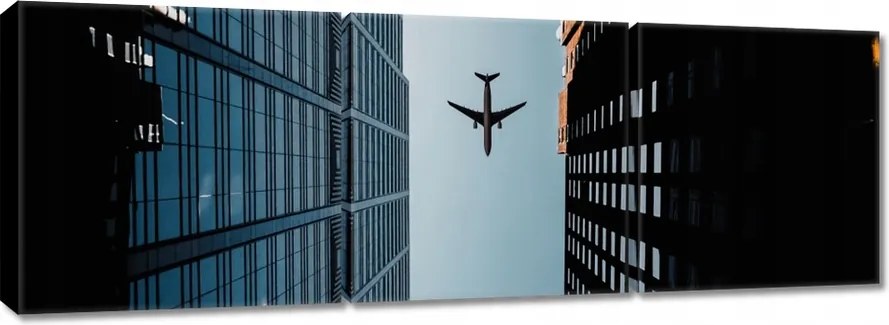 Vászonkép 150x50 Repülőgép az épületek között