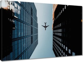 Vászonkép 100x70 Repülőgép az épületek között