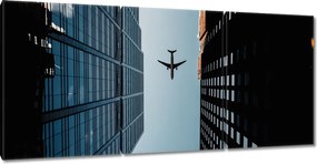 Vászonkép 210x100 Repülőgép épületek között