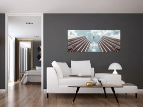 Repülőgép az épületek között képe (120x50 cm)