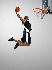 Fotográfia Basketball player dunking ball, low angle view, Blake Little