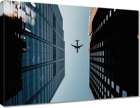 Vászonkép 70x50 Repülőgép épületek között