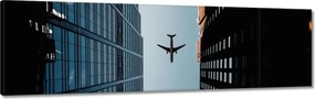 Vászonkép 170x50 Repülőgép az épületek között