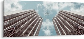 Repülőgép az épületek között képe (120x50 cm)