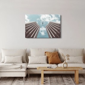 Repülőgép az épületek között képe (90x60 cm)