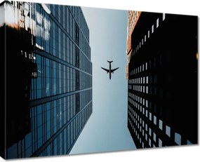 Vászonkép 80x60 Repülőgép az épületek között