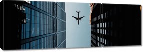 Vászonkép 150x50 Repülőgép az épületek között
