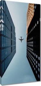 Vászonkép 55x115 Repülőgép az épületek között