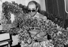 Fotográfia English Singer Elton John at his Arrival in Paris : Bunch of Flowers in The Shape of Glasses He Wears, December 1St, 1976